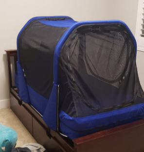 The Safety Sleeper on a dark wooden bed frame in a child's bedroom